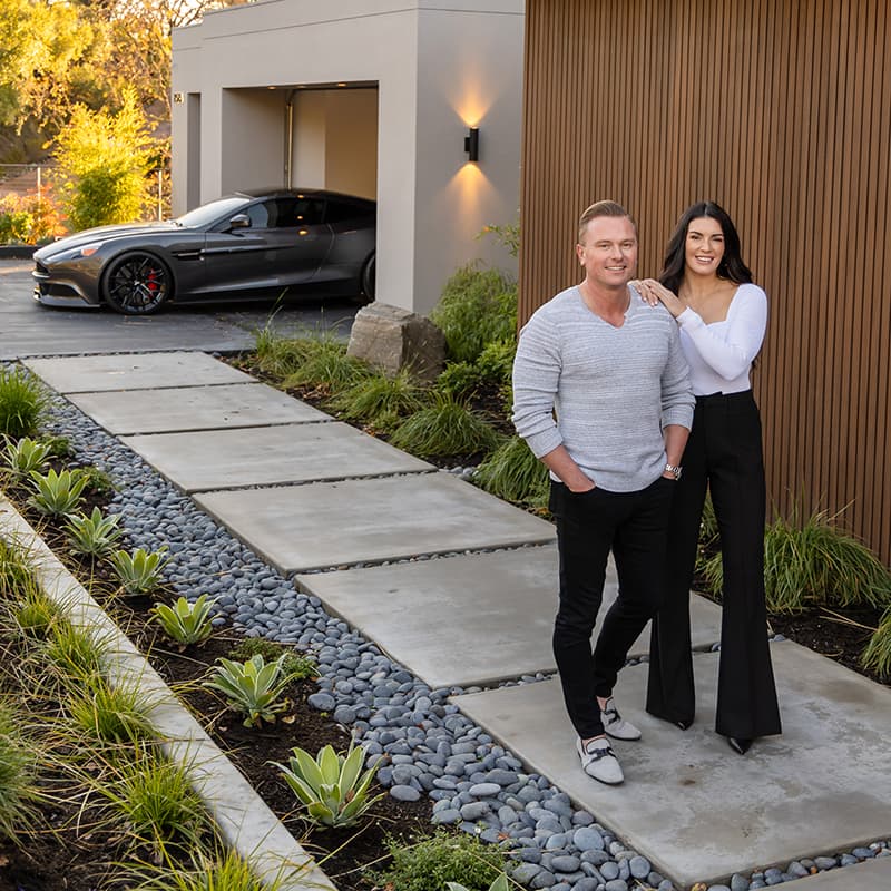 Anton Danilovich and Taylor Coyle in front of a modern Bay Area home